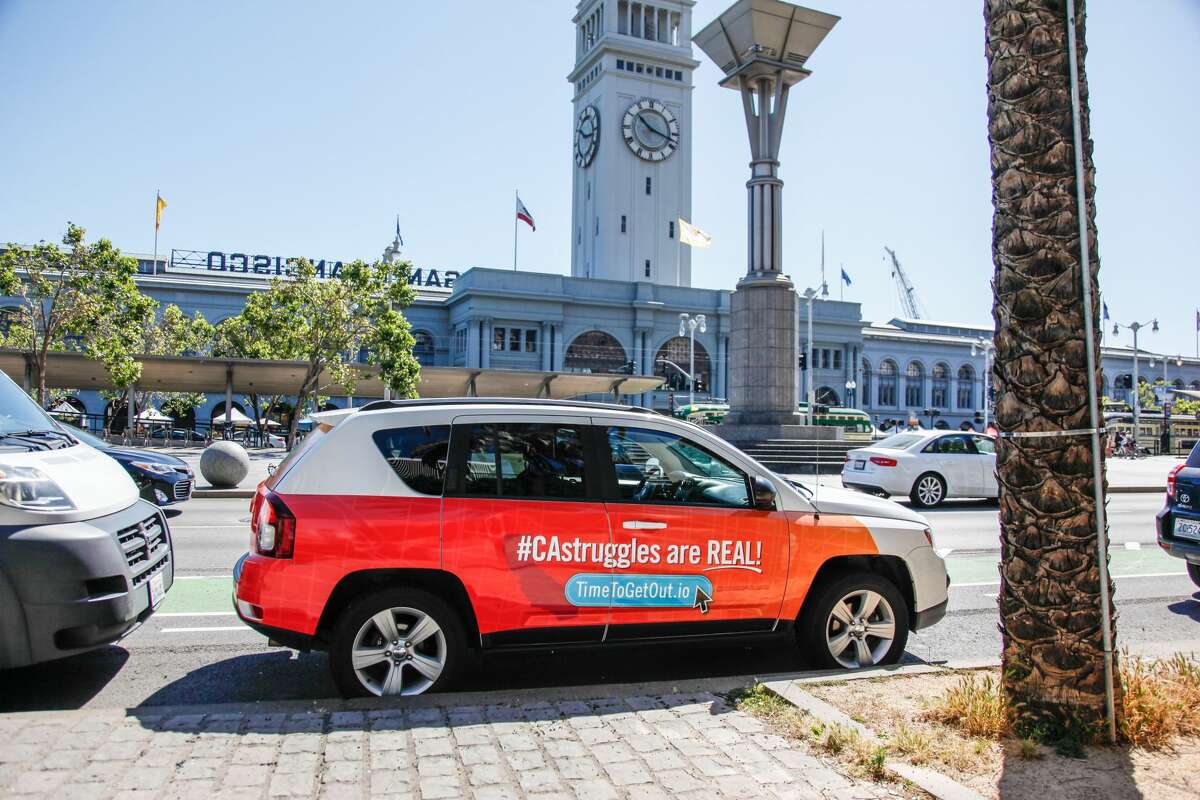 A car plastered with a wraparound ad proclaiming "#CAStruggles are REAL!" is part of a campaign by the Greater Phoenix Economic Council to court Californians to the Arizona capital.