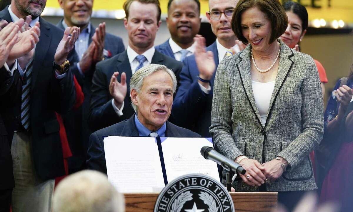 Texas Gov. Greg Abbott holds up a bill after signing it during a ceremony at Gallery Furniture on Thursday, June 13, 2019 in Houston.