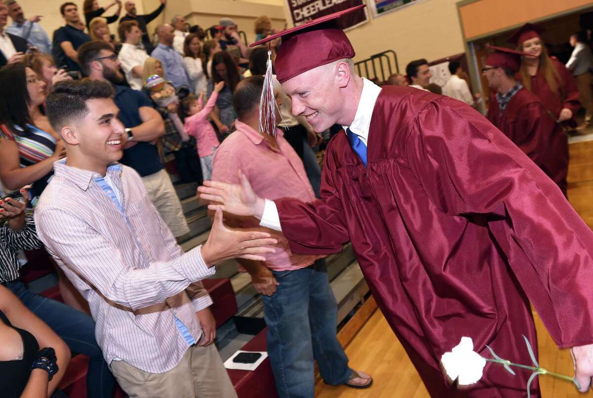 Colby Cusano (left) greets Shamus Meehan as he enters the gymnasium for the North Haven High School commencement on June 13, 2019.