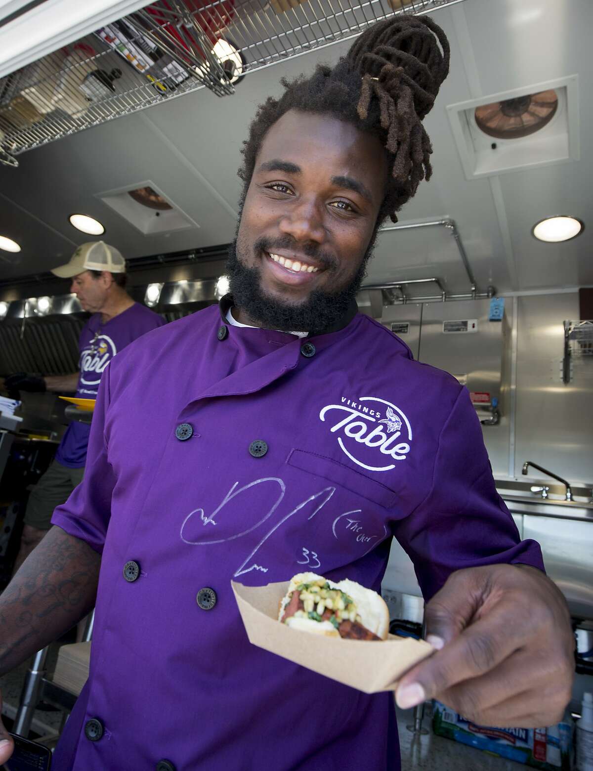 Minnesota Vikings running back Dalvin Cook serves food from the Vikings Table, a food truck that will serve free healthy meals to kids in need this summer, at the team's NFL football training facility in Eagan, Minn., Thursday, June 13, 2019. (AP Photo/Andy Clayton- King)