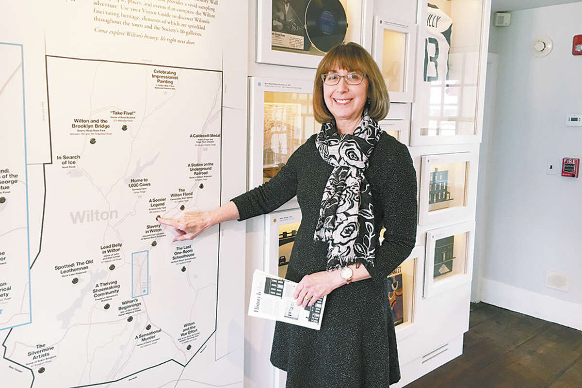 Wilton Historical Society co-director Allison Sanders presses a button on the interactive map in the new installation Connecticut’s History, Wilton’s Story. — Jeannette Ross photo