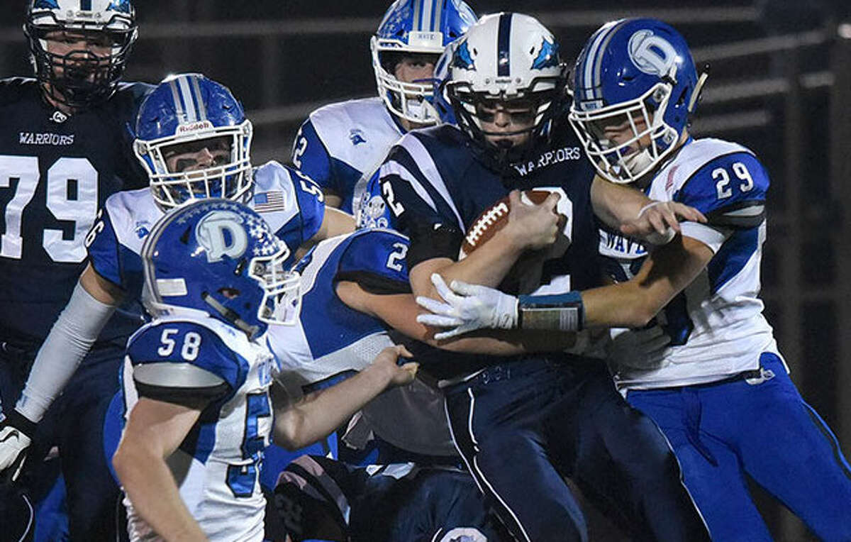 A swarm of Darien defenders puts the brakes on Wilton’s Kyle Phillips during the Wave’s 34-13 win on Friday night. — Dave Stewart photo