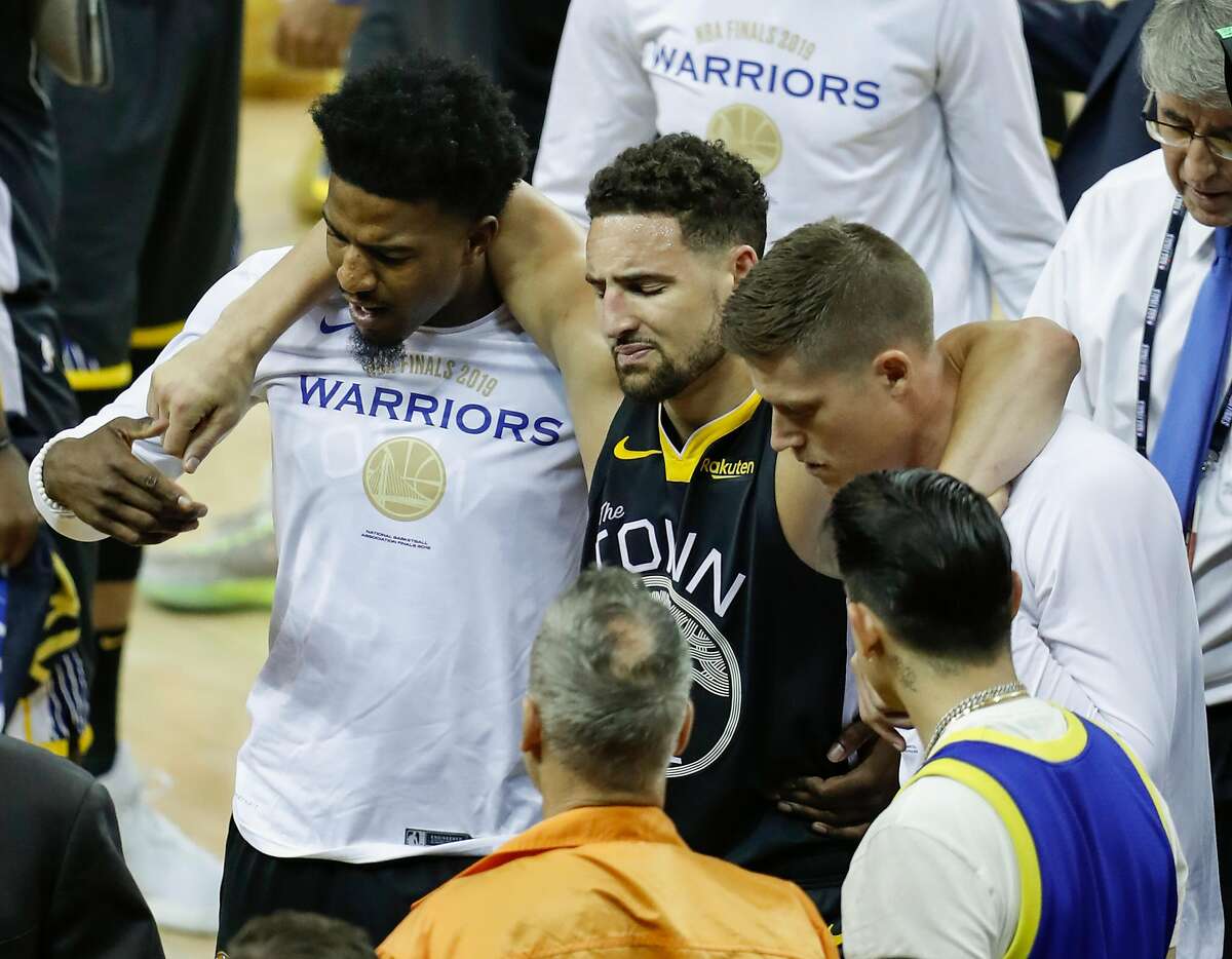 Golden State Warriors’ Klay Thompson is helped off the court by Jordan Bell and Jonas Jerebko in the third quarter during game 6 of the NBA Finals between the Golden State Warriors and the Toronto Raptors at Oracle Arena on Thursday, June 13, 2019 in Oakland, Calif.