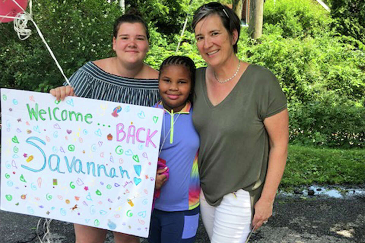 Vanessa Elias, right, and her daughter, Mia, left, welcome Savannah back for her second week in Wilton.