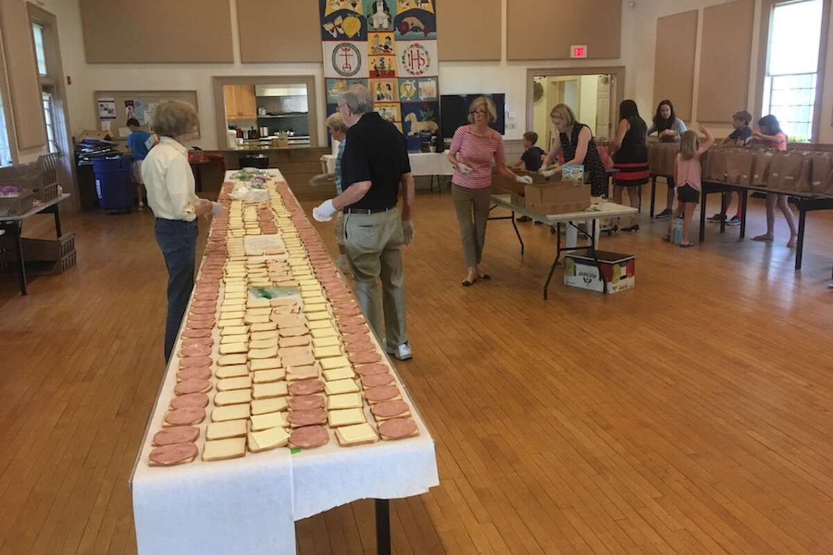 Volunteers at Wilton Congregational Church form an assembly line to make sandwiches for children in need.