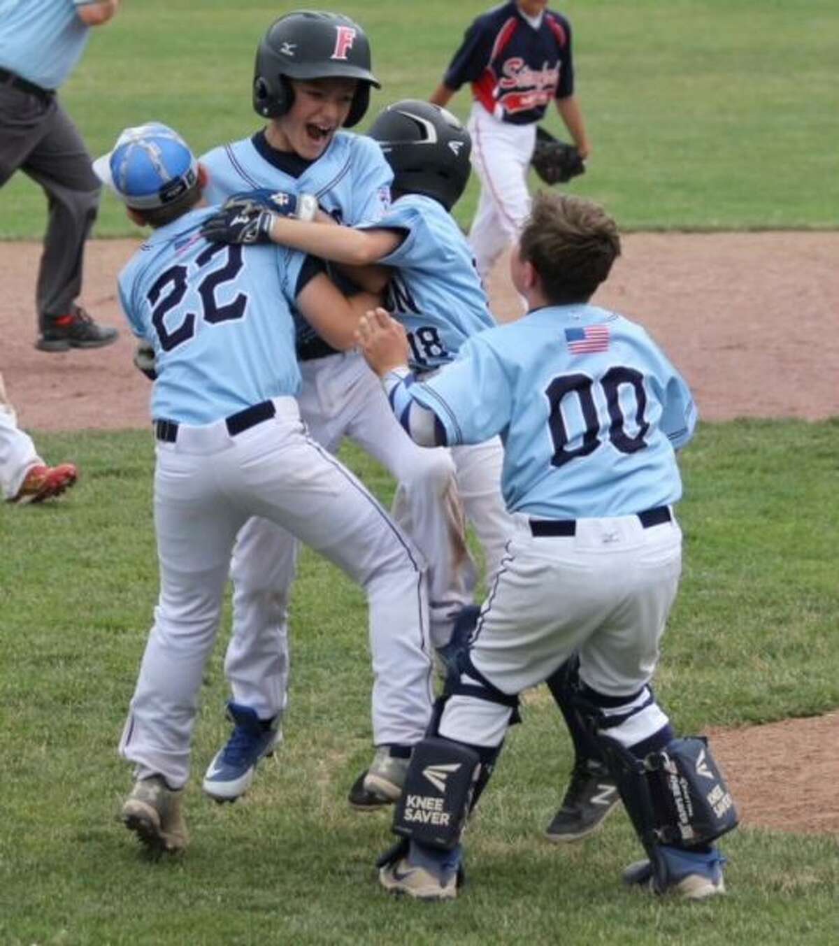 Tanner Schmauch is mobbed by his teammates after his RBI double in the bottom of the sixth gave the Wilton 11U baseball team a walk-off 10-9 win over Stamford North on Sunday. — Vin Forgione photo
