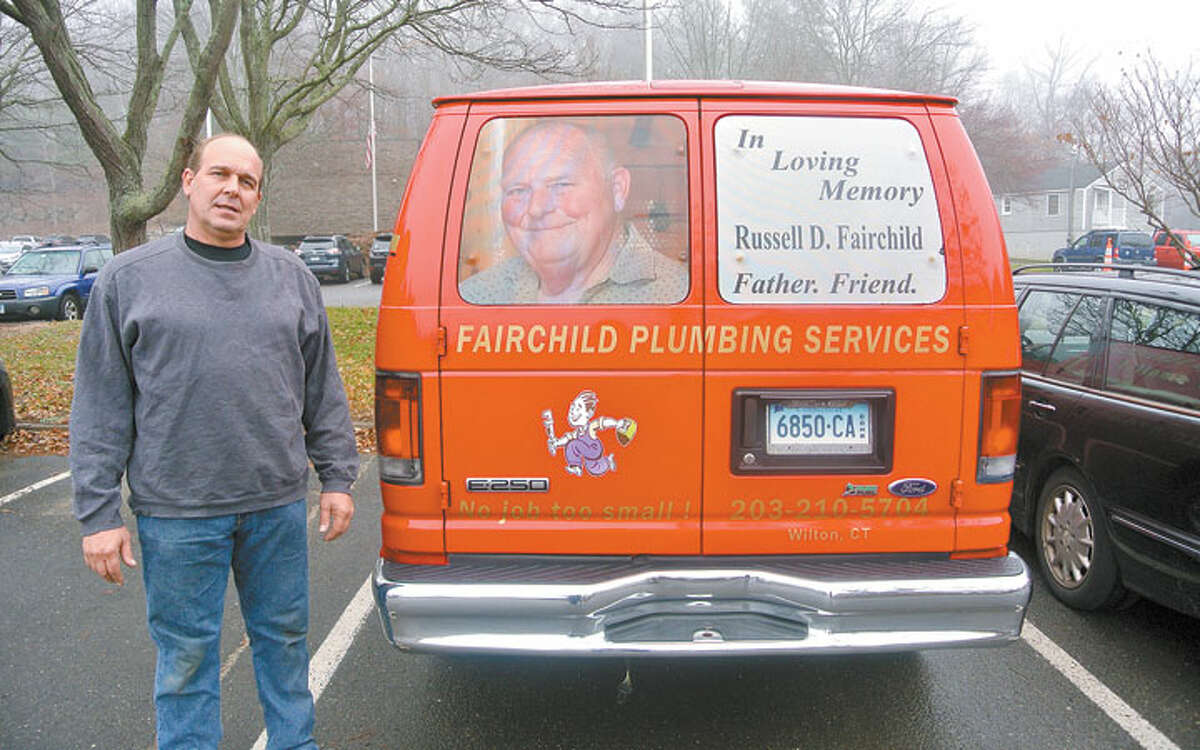 John Fairchild standing beside his business van, the back of which is decorated with memorial decals that remember his father, Russell D. Fairchild. Designs by A-to-Z Signs of Norwalk. — Hayden Turek photo