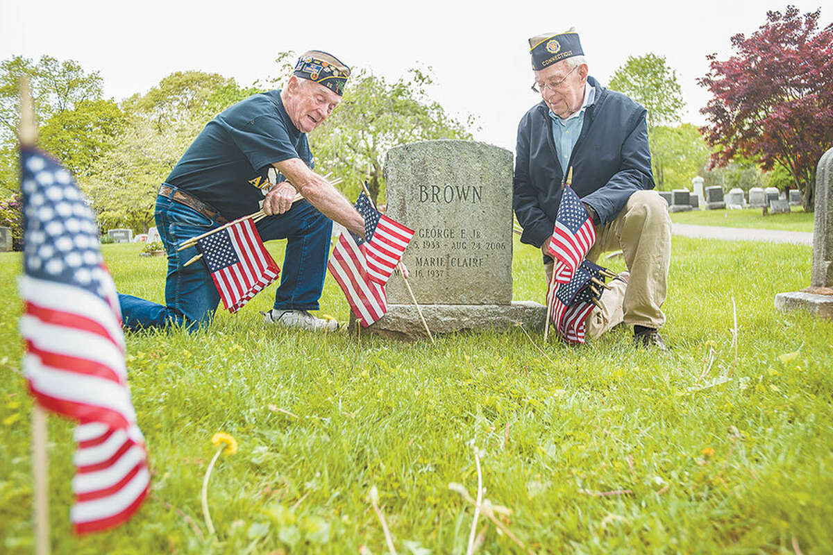 Air Force veteran Bing Ventres, left, and Judd Mott, a veteran of the Air National Guard of Connecticut, place flags at the graves of Wilton veterans in Hillside Cemetery. Both men served during the Korean War. Hillside will be the setting for a ceremony of remembrance at the end of the Memorial Day parade on Monday, May 28. — Bryan Haeffele photo