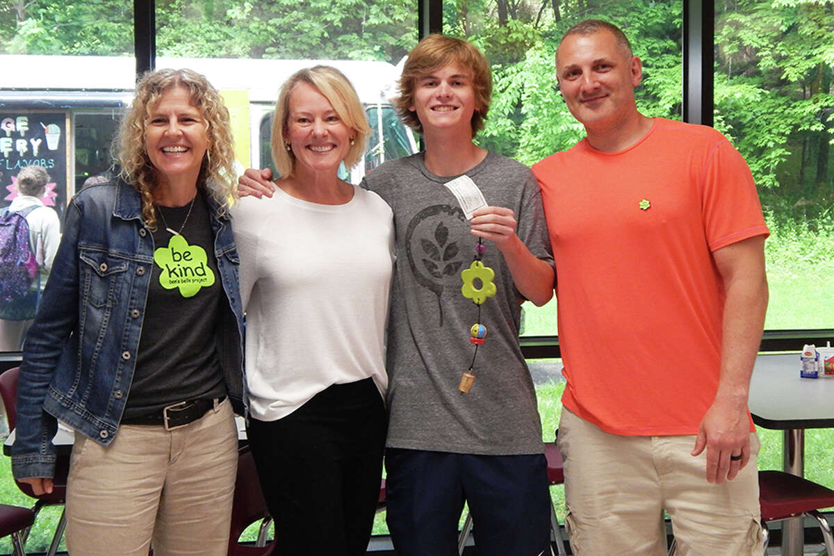 Tor Aronson, second from right, holds the Ben’s Bell he was presented with May 23 at Wilton High School. He is pictured with, from left, Ben’s Bells founder and executive director Jeannette Maré, his mother, Inger Sjogren; and Ben’s Bell Project regional manager Cody Foss.