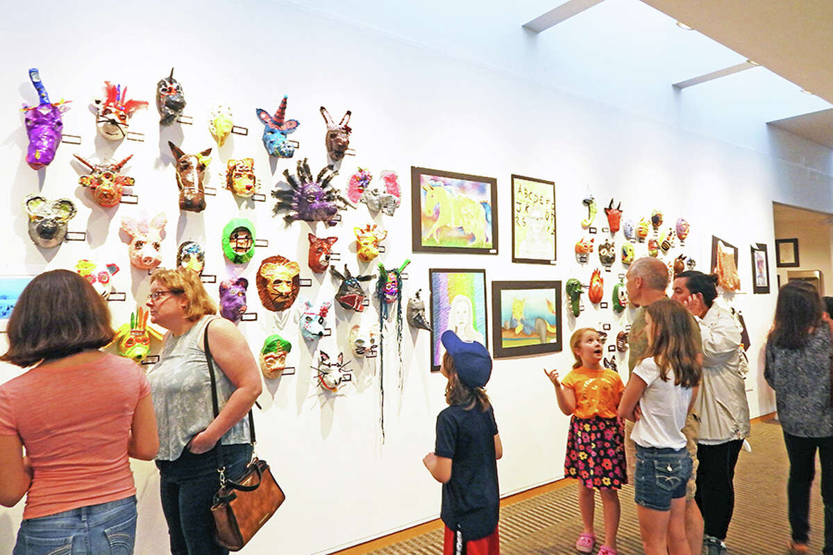 Visitors check out student artwork along the walls of Wilton Library.