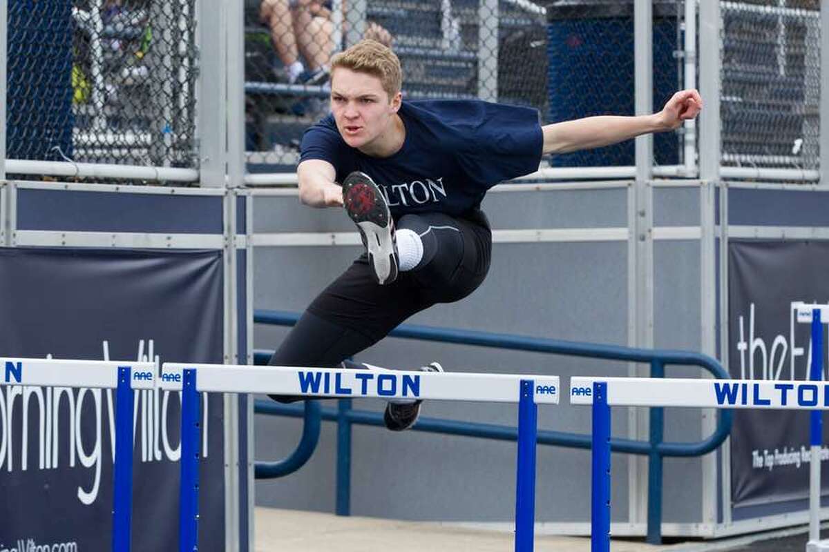Charlie Golbourn clears the barrier in the 110-meter hurdles during Wilton track and field action. — GretchenMcMahonPhotography.com