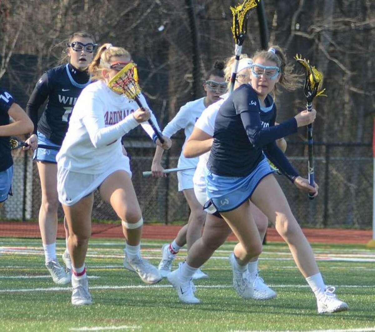 Olivia Roman tries to keep the ball away from a pair of Greenwich players during the Wilton High girls lacrosse team's win on Friday. — J.B. Cozens photo