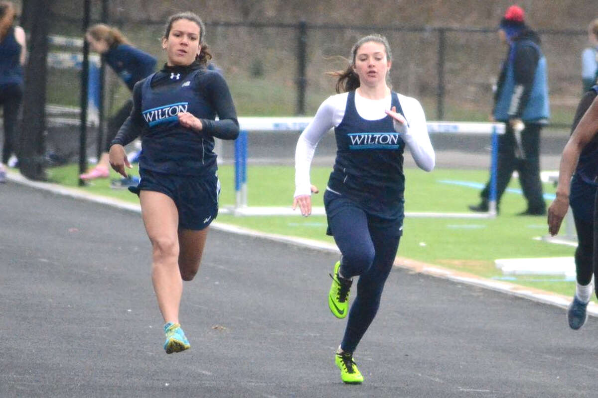 Claudia Nanez (left) and Tatem Kelly power down the track in the 100 meters at the Wilton track and field teams’ meet on Tuesday at home. — J.B. Cozens photo