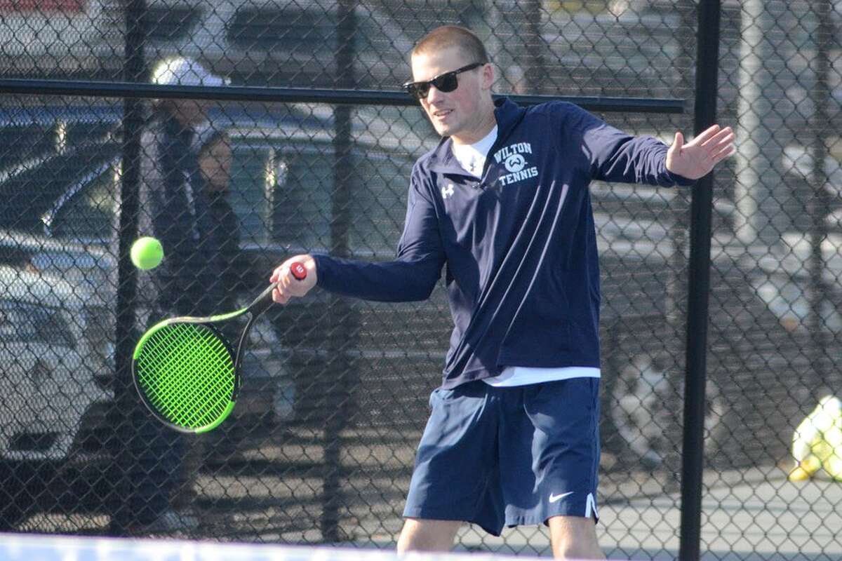 Owen McKessy plays a ball during the Wilton High boys tennis team's match on Thursday at home against New Canaan. — J.B. Cozens photo