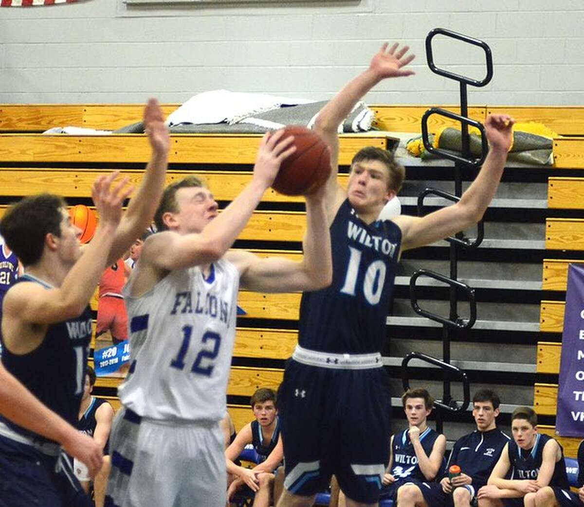 Kyle Phillips goes up to block a shot by Fairfield Ludlowe's Justin Schiller during the Wilton boys basketball team's win on Wednesday night. — J.B. Cozens photo