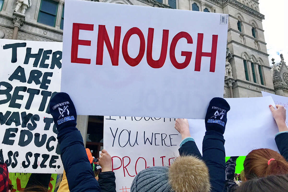 Wilton High School student Madeleine Pagliaro holds up an ‘ENOUGH’ sign at Hartford’s March for Our Lives rally.