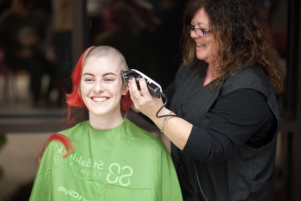 Dawn Pazar of Agron's Barbershop shaves Wilton High School junior Jasmine Whittaker’s head during this year’s St. Baldrick’s event in the Wilton High School cafeteria on March 15. — Adam Whittaker photo