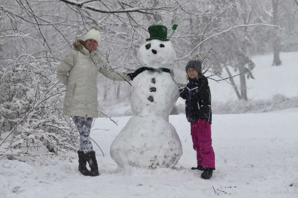 Kathryn Groves and her daughter Schuyler take advantage of the snow day and make a St. Patrick's Day snowman. — Brooks Garis photo