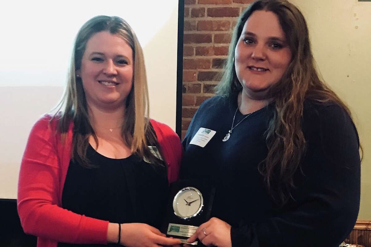 Sarah Wilby, left, presents Jennifer Bradshaw, childhood education coordinator at Woodcock Nature Center, with the 2019 Environmental Stewardship Award from the Connecticut Outdoor and Environmental Education Association on March 27 in Farmington.