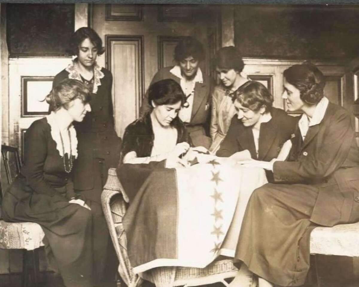 National Woman’s Party activists watch Alice Paul of Ridgefield sew a star onto the NWP Ratification Flag, representing another state’s ratification of the 19th Amendment. Contributed photo