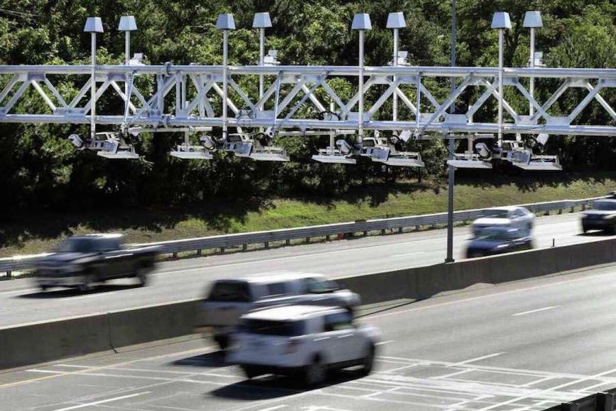 In a 2016 file photo, cars drove under electronic toll gantries on the Mass Pike. (AP Photo /Elise Amendola, File) /