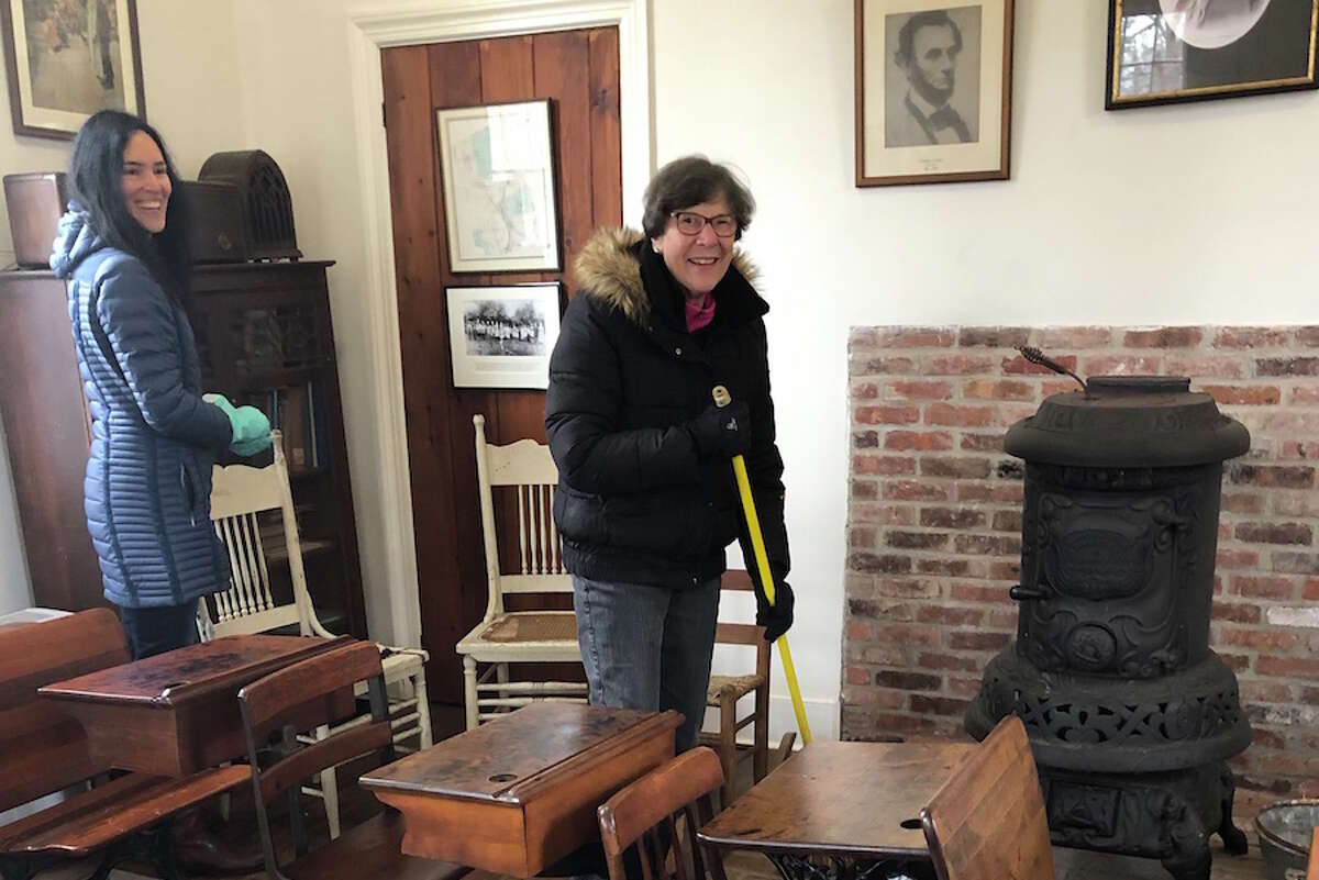 Chrissy Silva, left, and Linda Schmidt, chair of the Hurlbutt Street Schoolhouse Committee, clean up the schoolhouse in preparation for visits by Wilton students. - Contributed photo