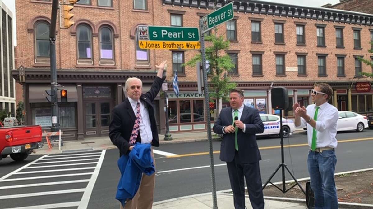 Albany County Executive Daniel McCoy and Albany city Treasurer unveil street sign renamed in tribute to the Jonas Brothers, which is coming to the Times Union Center in August. South Pearl Street has been temporarily renamed Jonas Brothers Way at the corner of Pearl and Beaver streets on June 14, 2019. (Amanda Fries / Times Union)
