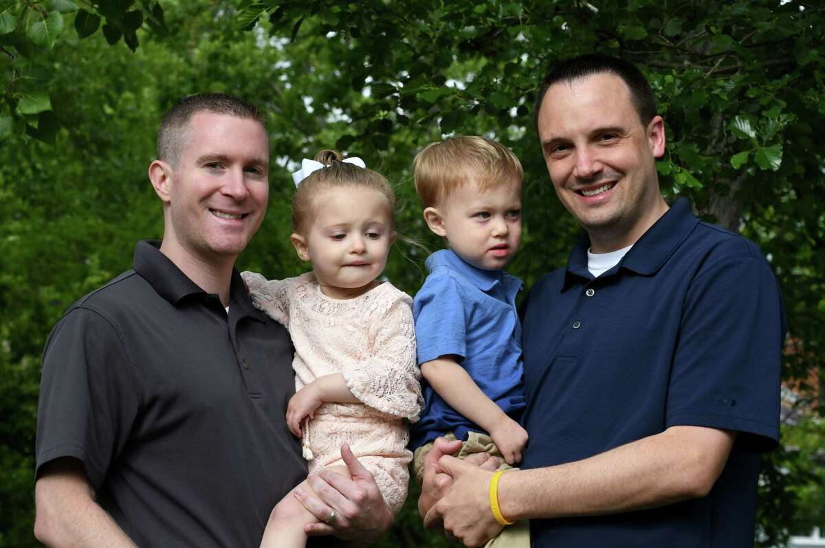 Kevin Karr-McGraw, left, and Sean McGraw, right, with their daughter and son on Friday, June 14, 2019, in Albany, N.Y. The married couple had their children through surrogacy. The process cost over $100,000 and involved multiple trips to California and Texas, where their twins were eventually born in 2017. (Will Waldron/Times Union)