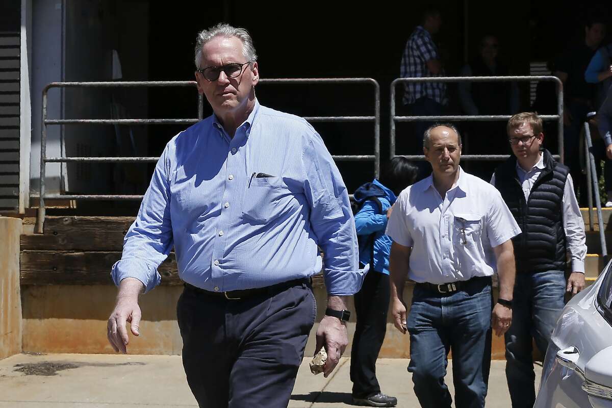 William Johnson, left, the chief executive officer for Pacific Gas & Electric Co., leaves the Paradise Performing Arts Center during a tour of fire ravaged Paradise, Calif., Friday, June 7, 2019. Johnson, the PG&E board and others leaders were ordered by United States District Judge William Alsup to tour the destruction caused last November's Camp Fire. (AP Photo/Rich Pedroncelli)