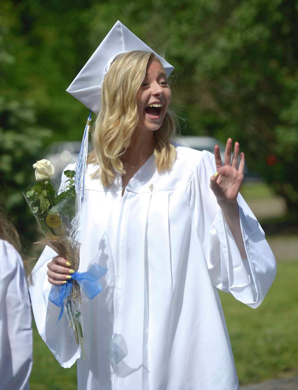 Lana Marie DelVecchio, of Bridgewater, waves during the procession for the Shepaug Valley High School Class of 2019 Commencement, Saturday morning, June 15, 2019, on the Bryan Memorial Town Hall lawn, Washington, Conn.
