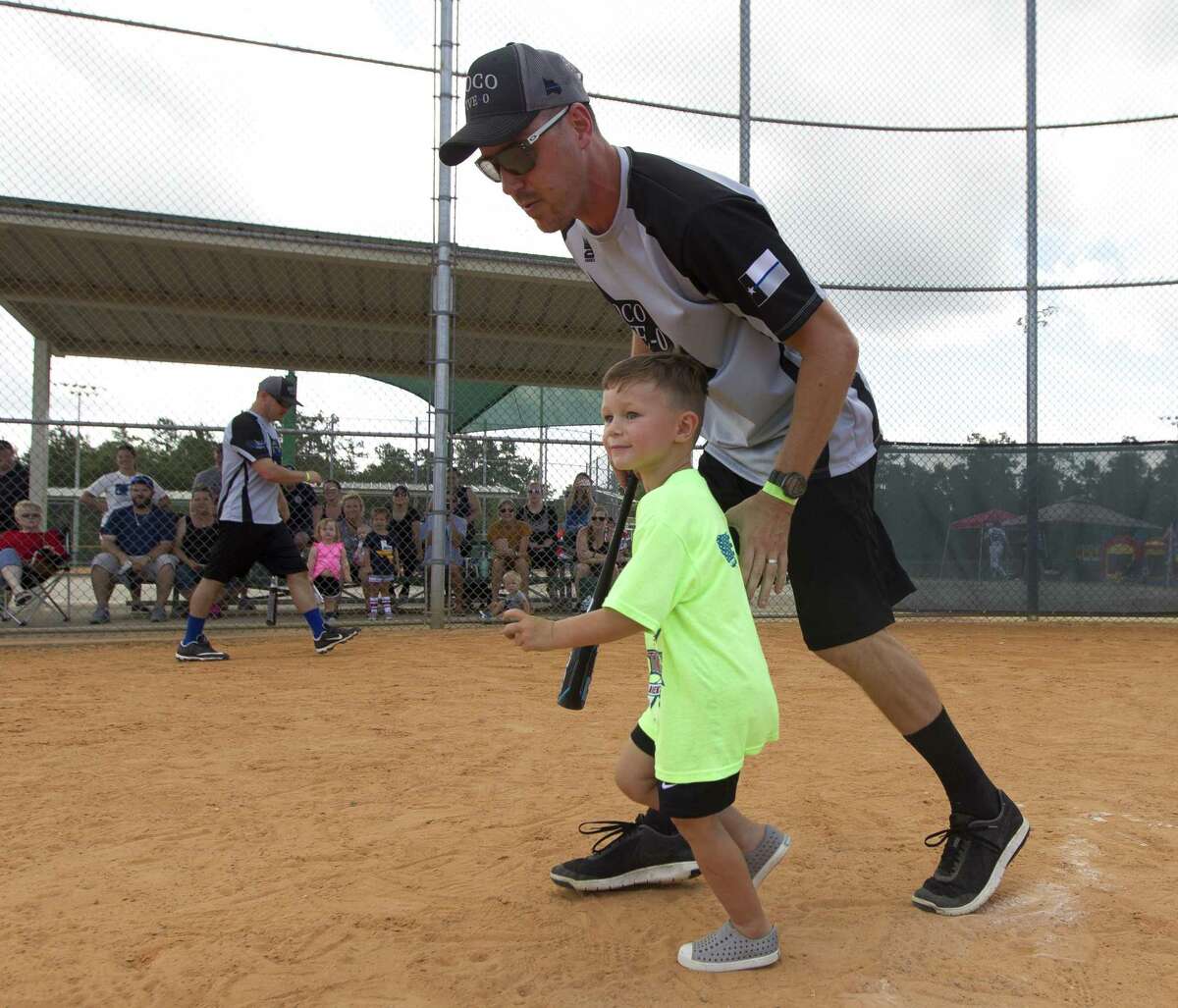 Patrick Reed runs with his son, Jackson, after a hit during the inaugural Americans Stand United First Responder Softball Tournament at Carl Barton, Jr. Park, Saturday, June 15, 2019, in Conroe. Each child was pair with a firefighter or police officer as a coach for the game. The inaugural tournament brought together community members with 150 first responders from Montgomery and Harris County.