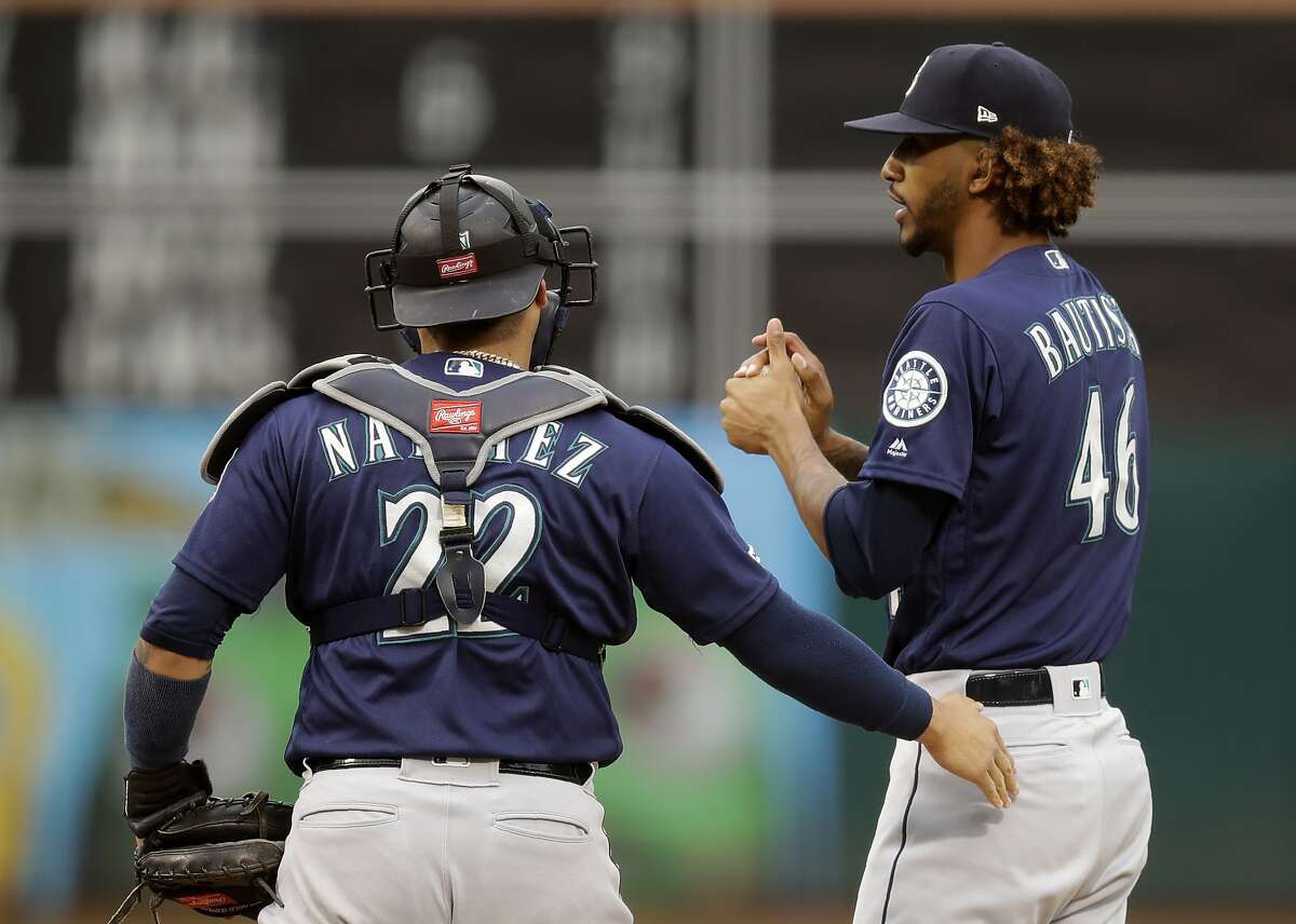 Seattle Mariners catcher Omar Narvaez, left, speaks with pitcher Gerson Bautista (46) in the first inning of a baseball game against the against the Oakland Athletics, Saturday, June 15, 2019, in Oakland, Calif. (AP Photo/Ben Margot)