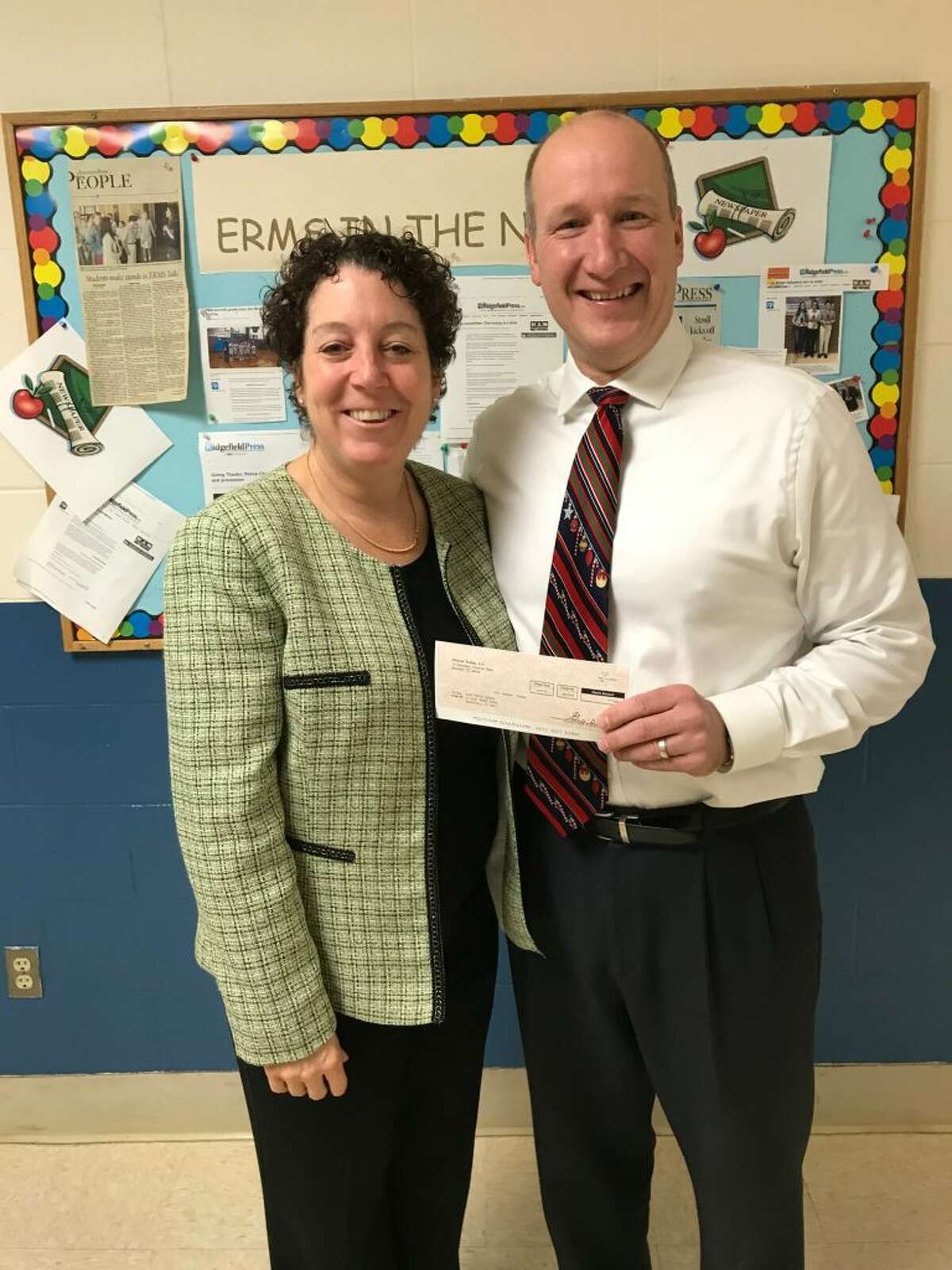 Mobil co-owner Todd Schoenherr with East Ridge Middle School principal Patricia Raneri in December.