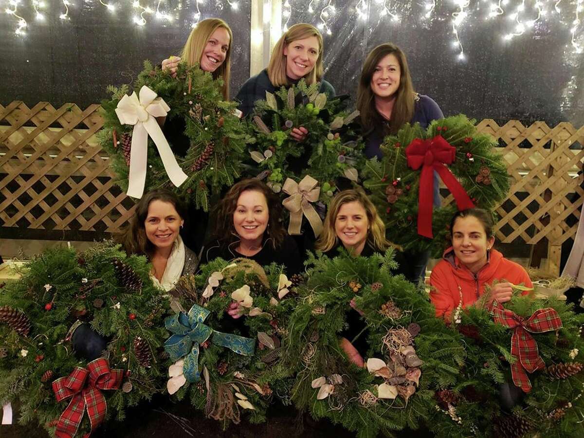 Local women show off their decorated wreaths at Woodcock Nature Center.