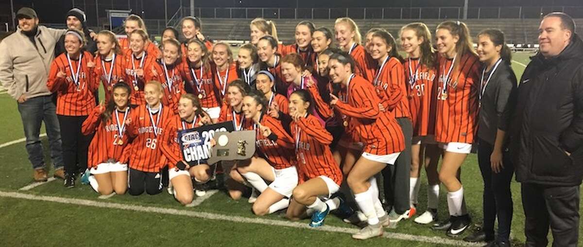 The Ridgefield High girls soccer team celebrates its 1-0 win over Staples in the Class LL state finals. - Tim Murphy photo