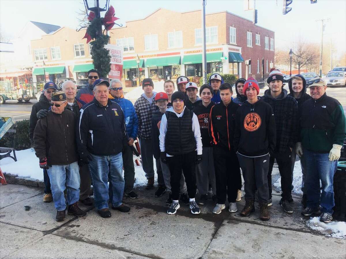 American Legion Post 78 members and baseball players they sponsor teamed up last weekend to decorate the lammposts around the village in time for the Festival of Lights in front of town hall Friday, Nov. 23.