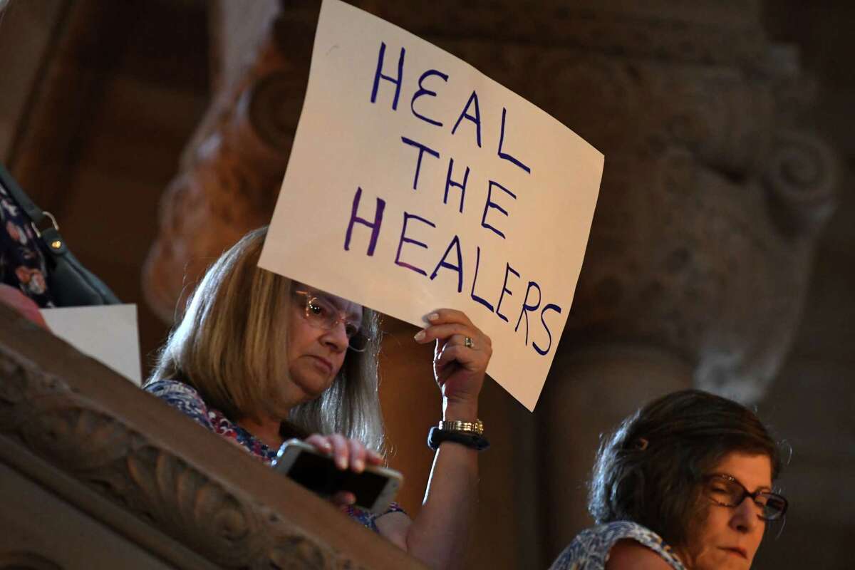 St. Clare's Hospital retirees and workers display signs during a press conference where lawmakers urged the state to launch an investigation of the hospital's pension fund collapse on Monday, June 17, 2019, at the Capitol in Albany, N.Y. Last year, over 1,000 former employees and retirees were notified their pensions would be eliminated or significantly decrease. (Will Waldron/Times Union)