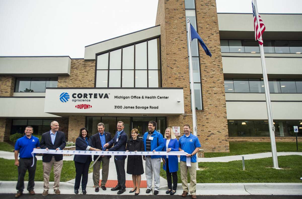 U.S. Rep. John Moolenaar, second from left, Susan Lewis, senior vice president of enterprise operations for Corteva Agriscience, third from left, Jim Collins, chief executive officer of Corteva Agriscience, fourth from left, David Midkiff, director of operations for Corteva Agriscience, fifth from left, and Midland Mayor Maureen Donker, fifth from left, along with additional Corteva staff, pose for a photo before cutting a ribbon during an event celebrating the agriculture company on Monday, June 17, 2019 at 3100 James Savage Road in Midland. (Katy Kildee/kkildee@mdn.net)