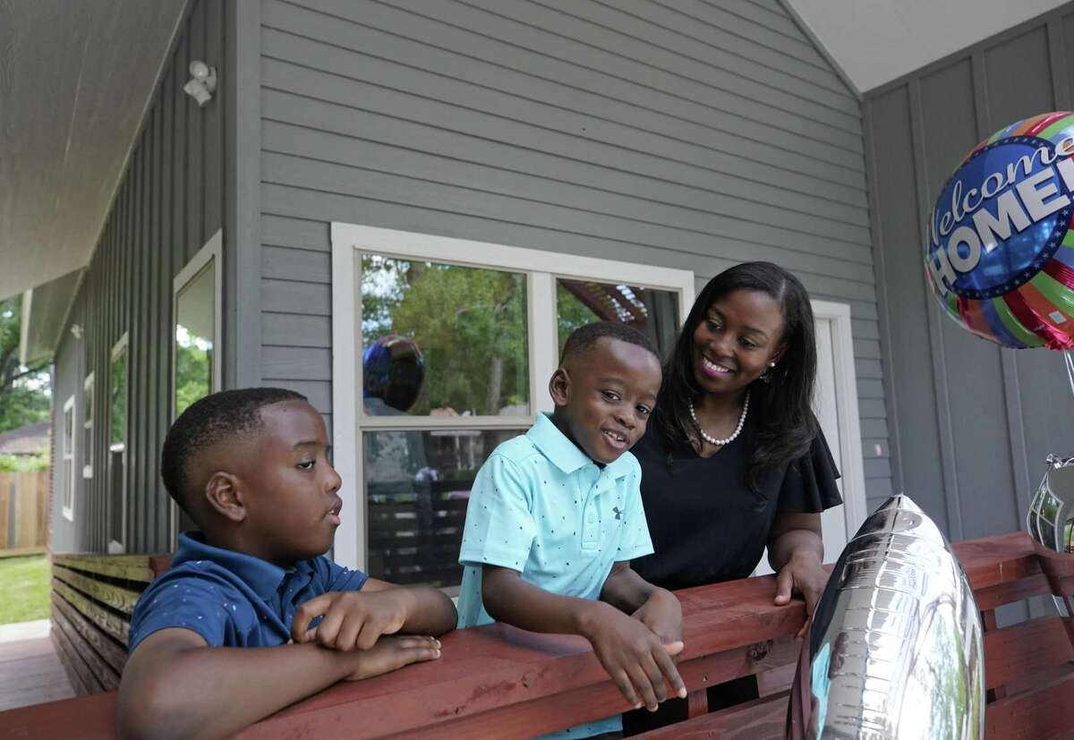 Sabrina Starks-Tarble with her sons, Drew Tarble, 9, and Cameron Tarble, 5, stand on the front porch of their new home in Acres Home Friday, June 7, 2019, in Houston. She purchased the home through the Houston Community Land Trust.