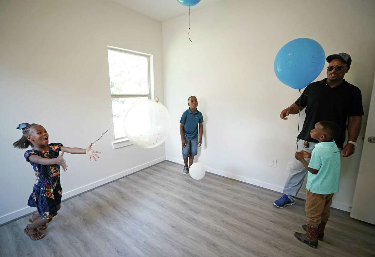 Leaira Tarble, 7, left, with her brothers, Drew Tarble, 9, and Cameron Tarble, 5, and their grandfather, Fred Starks, play in the boys’ bedroom at the children’s new home on June 7, 2019, in Houston. Their mother, Sabrina Starks-Tarble, purchased the home through the Houston Community Land Trust.