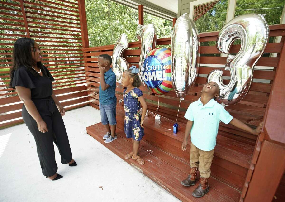 Sabrina Starks-Tarble, left, gathers her children Drew Tarble, 9, Leaira Tarble, 7, and Cameron Tarble, 5, for a photo outside their new home in Acres Home Friday, June 7, 2019, in Houston. She purchased the home through the Houston Community Land Trust.