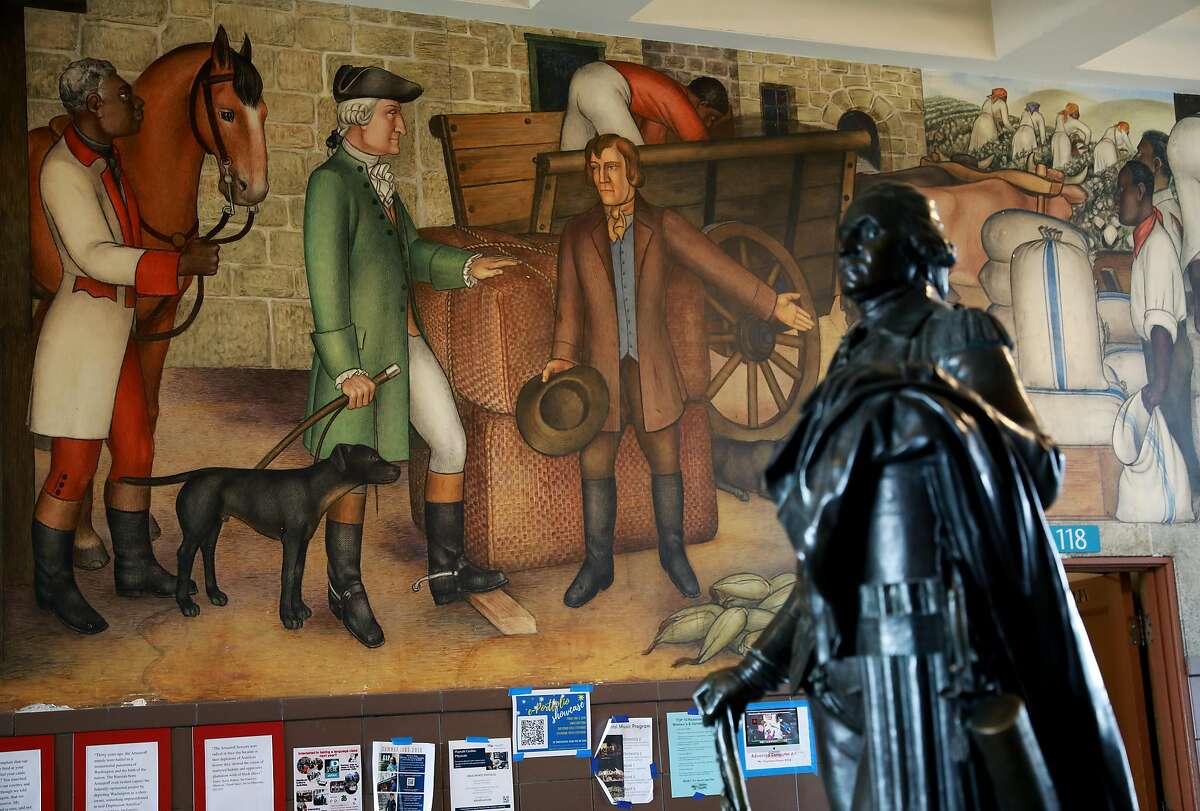 A statue of George Washington stands near a historic mural that depicts the treatment of American Indians and African Americans. San Francisco school officials are expected to decide whether to destroy or keep the historic mural at George Washington High School, photographed in San Francisco, Calif., on Wednesday, April 3, 2019.