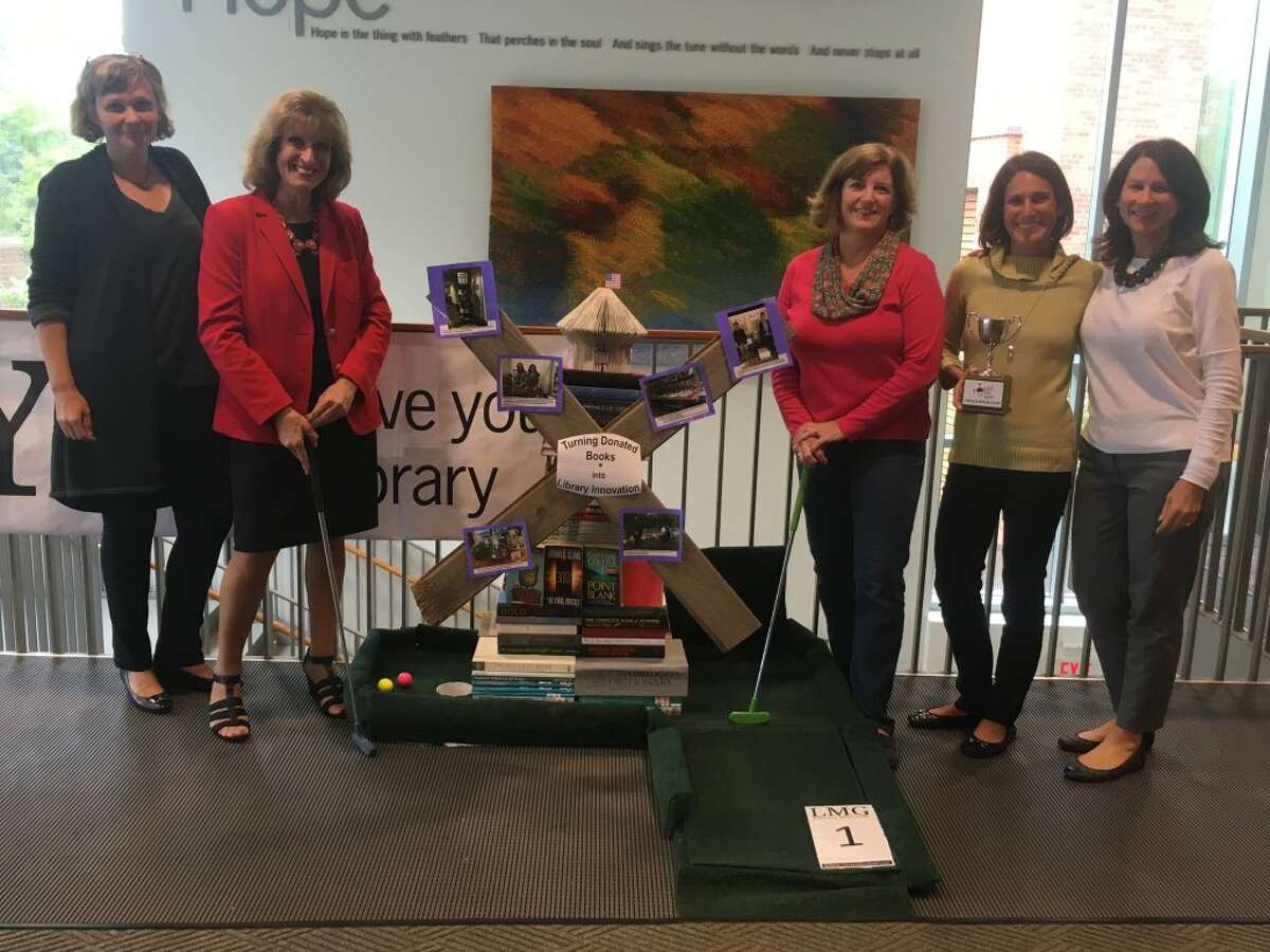 How does the Ridgefield Library become a 18-hole mini golf course? Just ask Love Your Library organizers Magda Fincham, Laureen Bubniak, Julie Yaun, Tizzie Mantione and Connie Marsala. The two-day event kicks off with Teen Night for young golfers from 6:30 to 10 Friday, Sept. 28. Family Open Play golf will be held 10 a.m. to 4 p.m. Saturday, Sept. 29, concluding with The Challenge Cup (which Mantione is holding in the above photo) at 7:30 p.m. — Steve Coulter photo