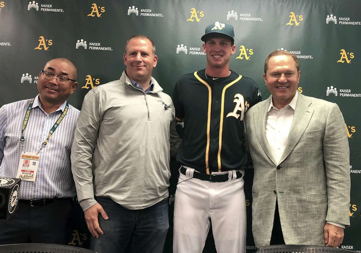 From left to right, Oakland Athletics scouting director Eric Kubota and general manager David Forst stand beside new draft pick Logan Davidson and his agent Scott Boras after a media conference prior to a baseball game against the Baltimore Orioles, Monday, June 17, 2019, in Oakland, Calif. (AP Photo/Janie McCauley)