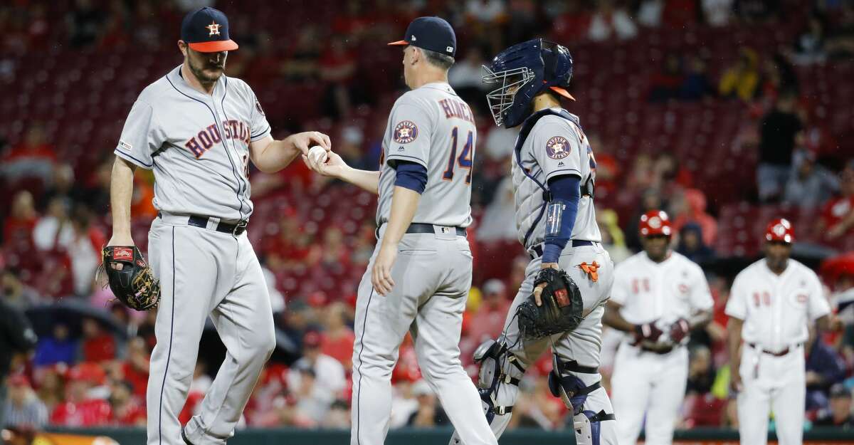 Houston Astros starting pitcher Wade Miley, left, is relieved by manager AJ Hinch (14) after walking Cincinnati Reds' Yasiel Puig in the fifth inning of a baseball game, Monday, June 17, 2019, in Cincinnati. (AP Photo/John Minchillo)