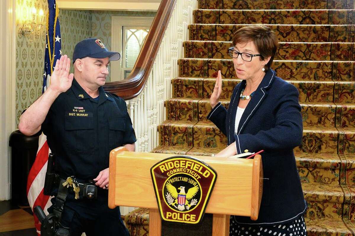 Ridgefield police officer Shawn Murray is sworn in as a sergeant by Town Clerk Wendy Lionetti Wednesday, April 16, at the Lounsbury House.