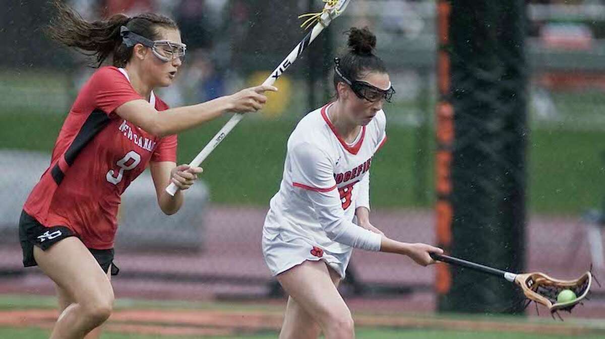 Hannah Boylan keeps the ball away from New Canaan's Katelyn Sparks during Monday's game. - Scott Mullin photo