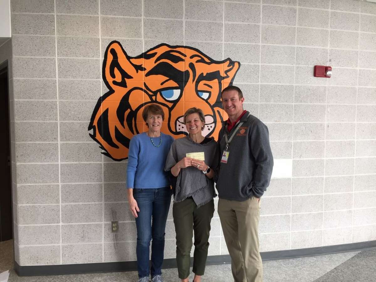 RTS treasurer Carol Gardell, left, presents a check for a new scoreboard project to Jill Bornstein president of Tiger Hollow Inc, and Dane Street, Ridgefield High School Athletic Director.