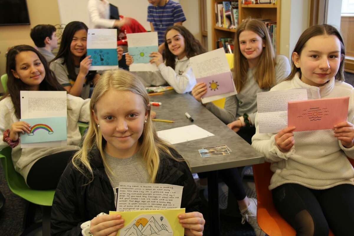 Seventh grade students at Ridgefield Academy hold up letters they have to Tanzanian students at the Mungere school where science teacher Mac Rand will be visiting in mid March. Rand plans to hand deliver the letters and start a back and forth relationship between the two schools.