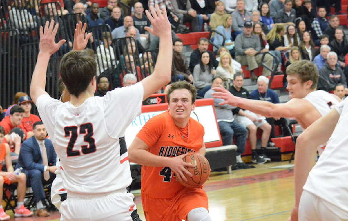 Chris Knachel drives to the basket during Ridgefield's win over New Canaan in the FCIAC quarterfinals. - Andy Hutchison photo